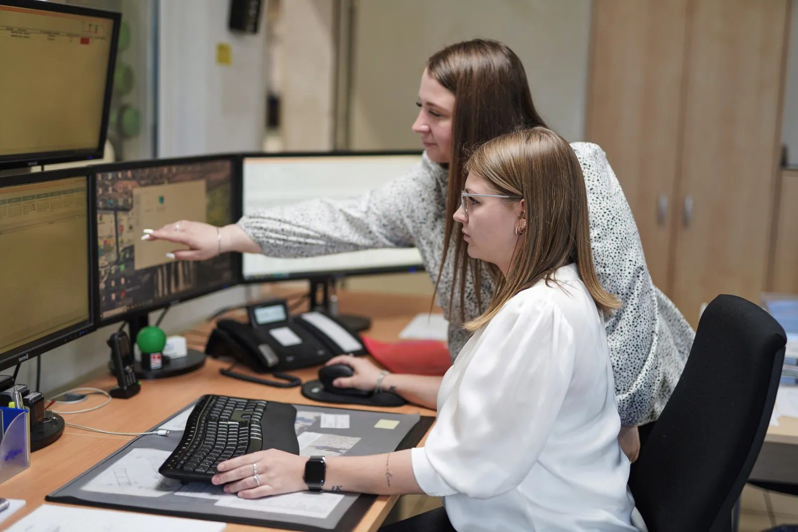 Zwei Mitarbeiterinnen besprechen etwas am Bildschirm im Büro