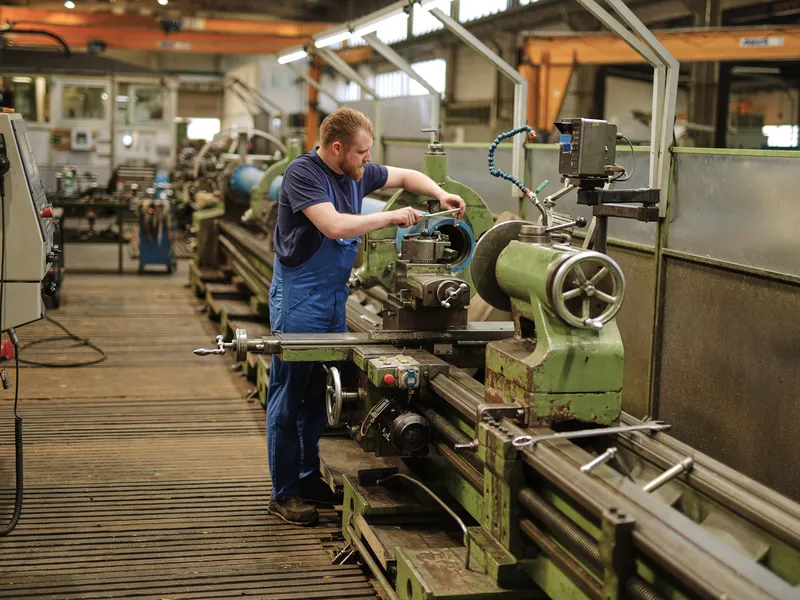 Mitarbeiter arbeitet an einer konventionellen Drehmaschine