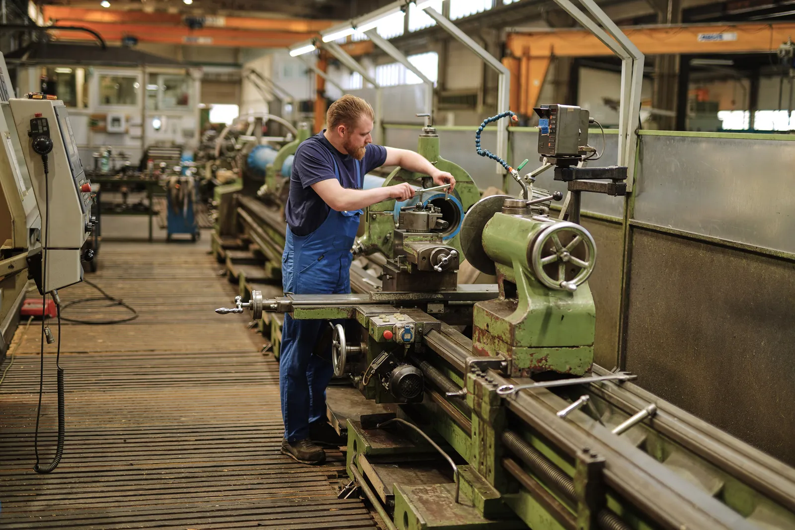 Mitarbeiter arbeitet an einer konventionellen Drehmaschine