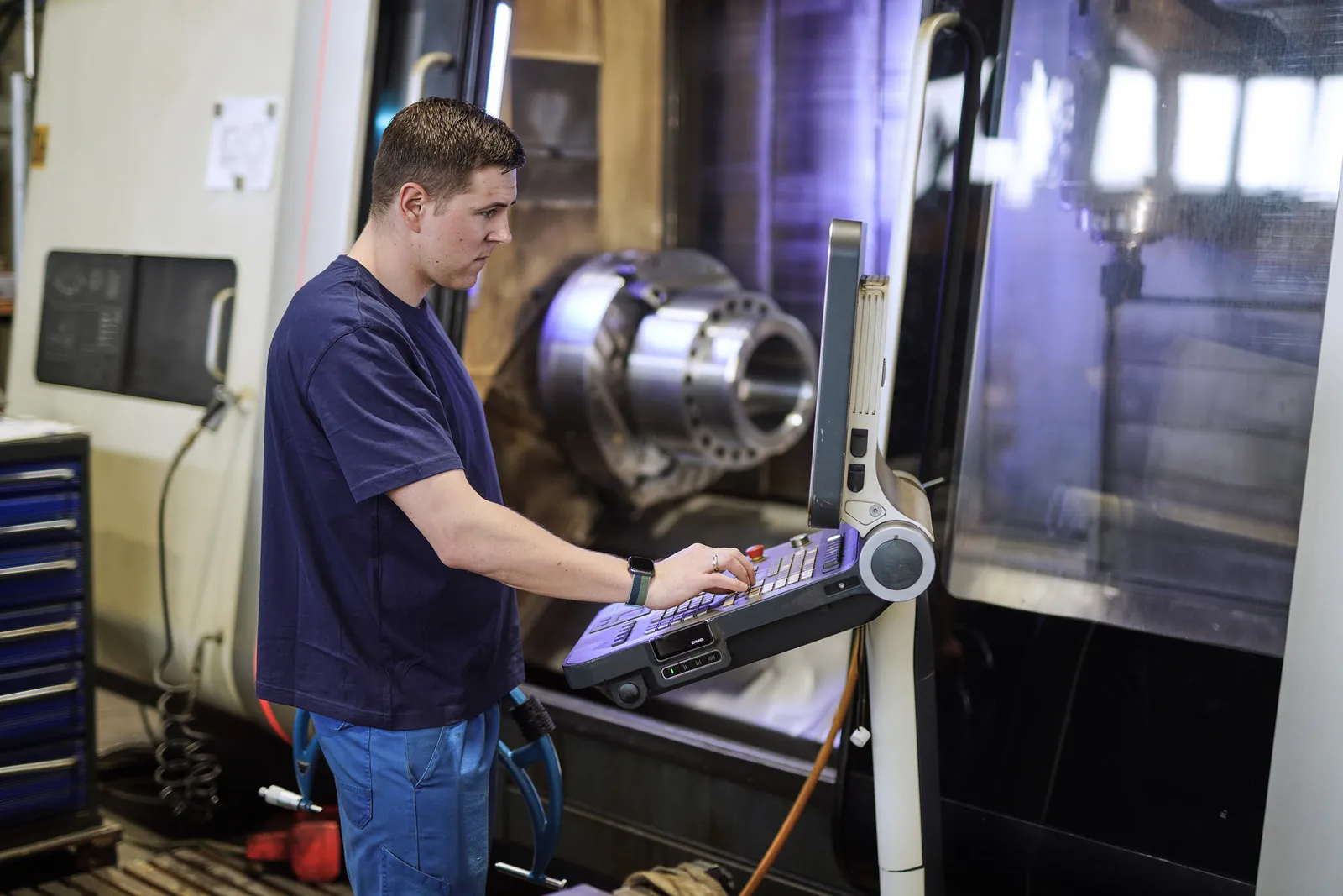 Mitarbeiter programmiert am Bedienpult einer CNC-Drehmaschine