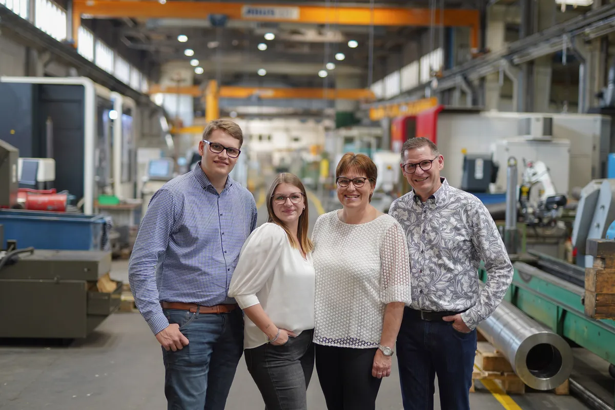 Die Familie Schmitz, vier Personen, steht in der Werkhalle zwischen den Maschinen