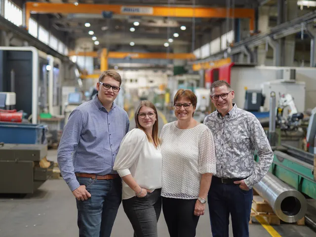Die Familie Schmitz, vier Personen, steht in der Werkhalle zwischen den Maschinen